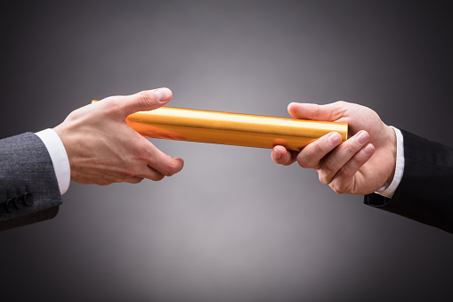 Person Passing Baton To Businessperson