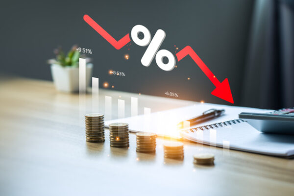 Low Risk Investment Concept, Stacks Of Coins And An Arrow Graph Pointing Down To The Lowest Point. Reduce Financial Risk For Investments And Capital. Risky Investment