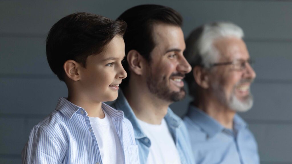 Head Shot Of Three Generations Of Men Standing In Row