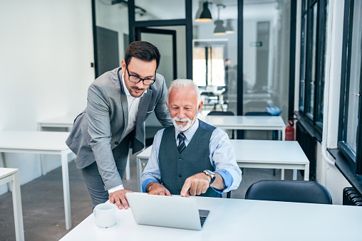 Business People Working On Laptop. Senior And Young Business Man Looking At Laptop Screen.